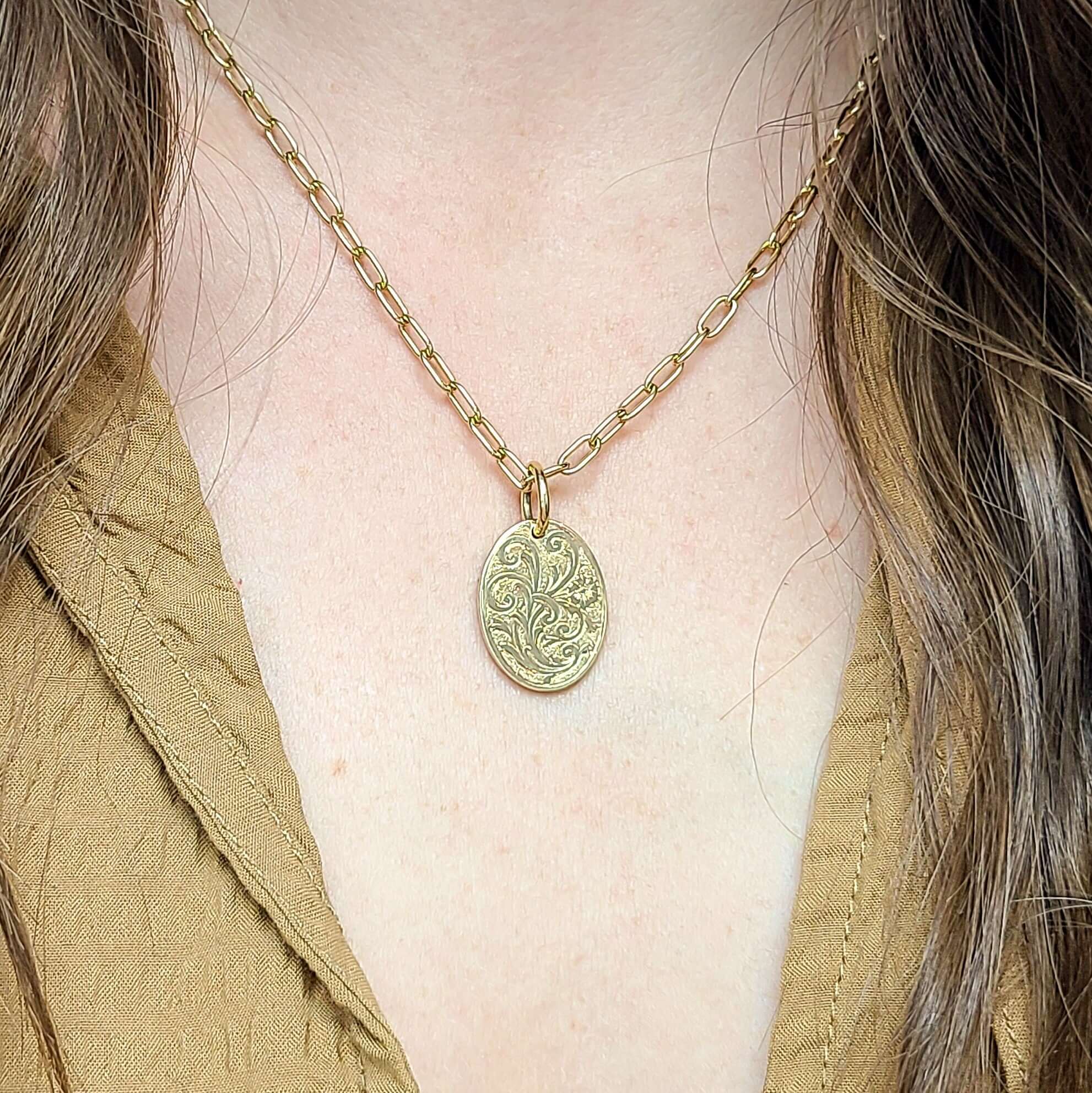 SINGLE STONE 20mm FLORAL ENGRAVED OVAL PENDANT PENDANT featuring Handcrafted 20mm floral engraved oval shaped pendant in 18K yellow gold. Price does not include chain.