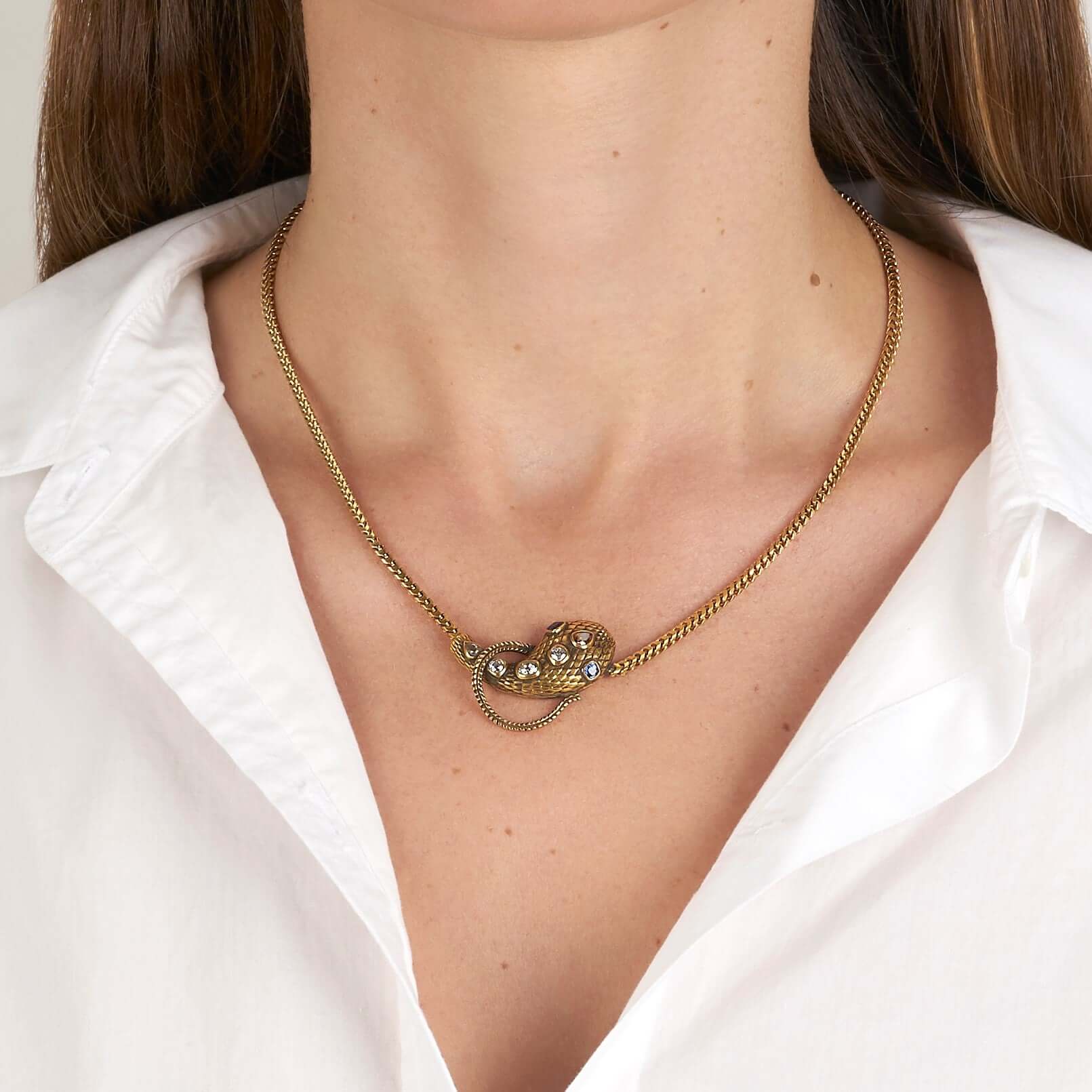 SINGLE STONE ALEXANDRIA SERPENT NECKLACE featuring 0.86ctw antique old mine, antique cushion, and pear cut diamonds featuring 0.44ctw cushion cut blue sapphire accent stones set on a handcrafted, oxidized 18K yellow gold snake pendant. Includes18K yellow