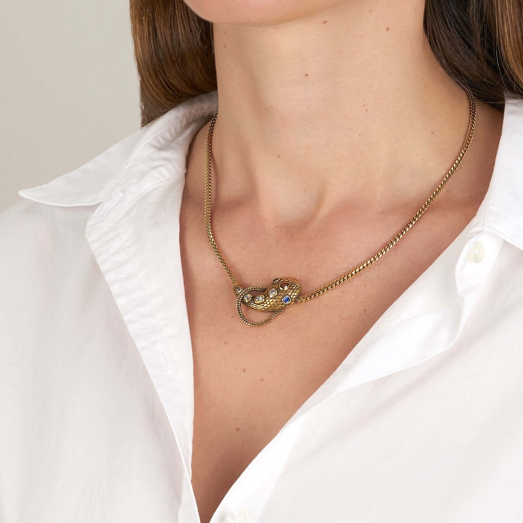 SINGLE STONE ALEXANDRIA SERPENT NECKLACE featuring 0.86ctw antique old mine, antique cushion, and pear cut diamonds featuring 0.44ctw cushion cut blue sapphire accent stones set on a handcrafted, oxidized 18K yellow gold snake pendant. Includes18K yellow