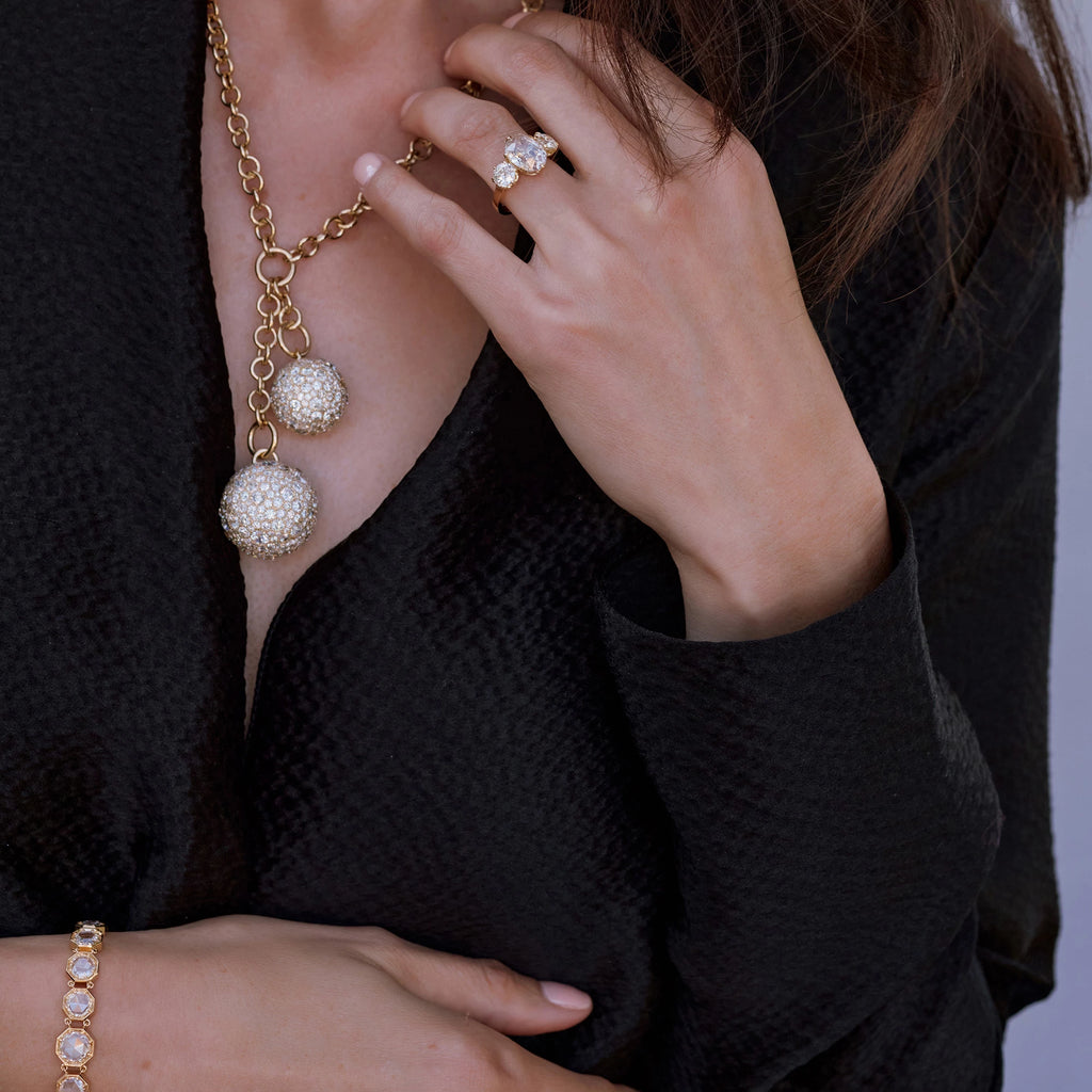 Close up of a woman in a blazer wearing a ring, necklace, and bracelet from Single Stone's "From the Vault" collection