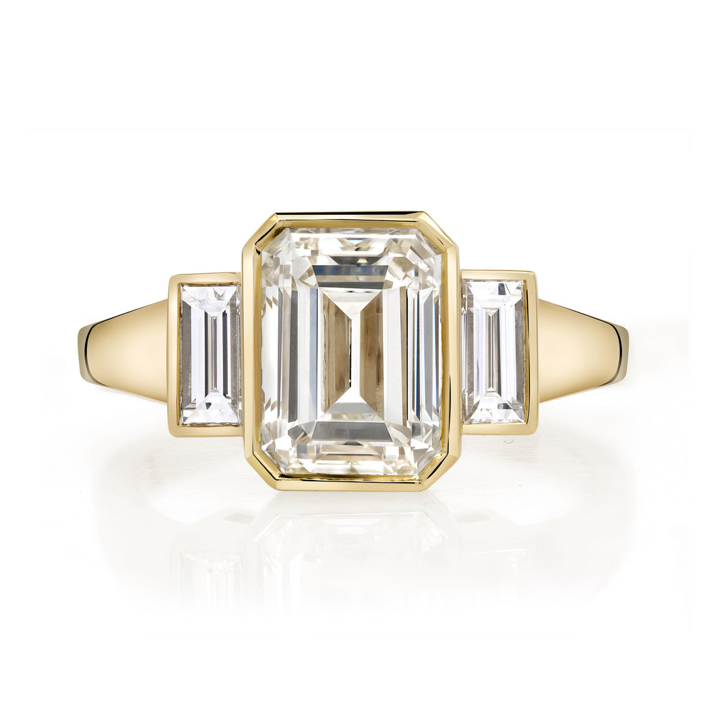 
Single Stone's Amelia ring  featuring 2.22ct N/VVS1 GIA certified emerald cut diamond with 0.37ctw baguette cut accent diamonds bezel set in a handcrafted 18K yellow gold mounting.

 
