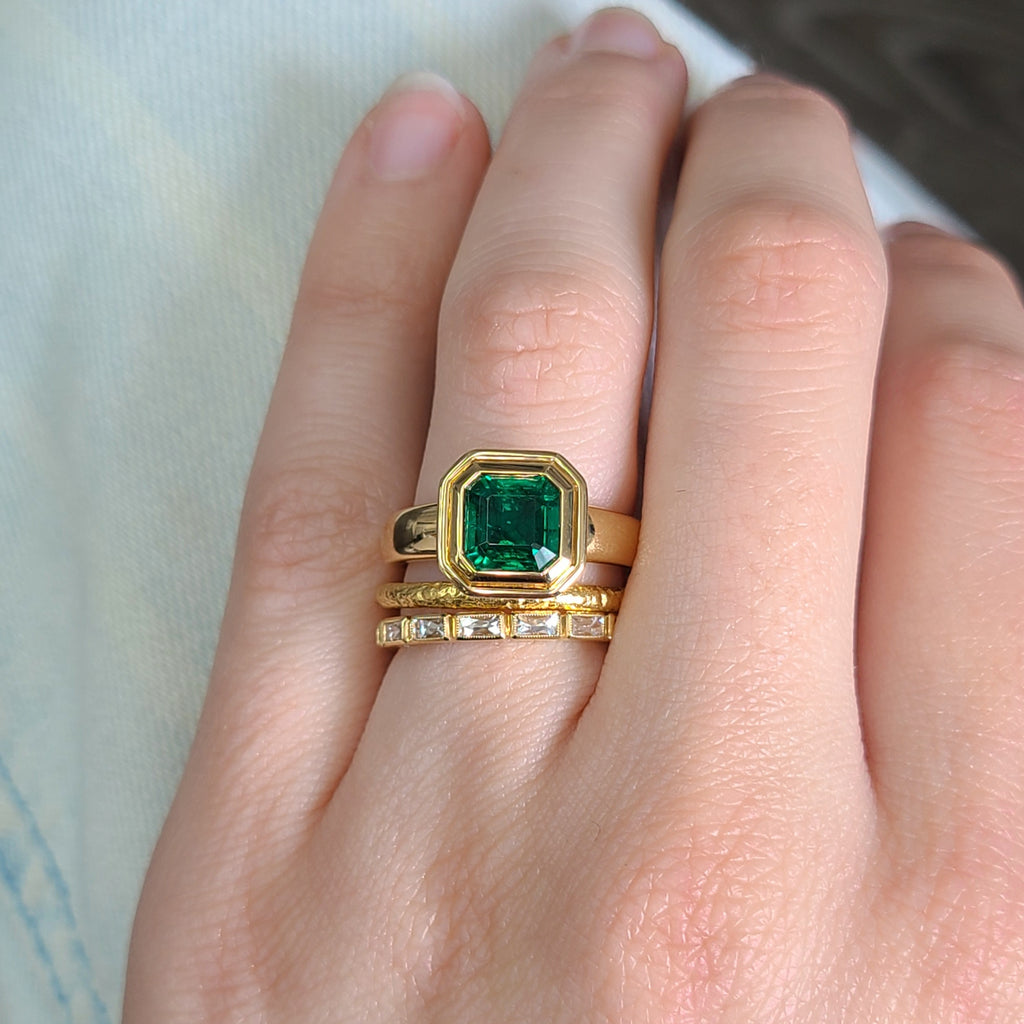 Single Stone's ARIA ring  featuring 1.90ct GIA certified Zambian Asscher cut natural green emerald bezel set in a handcrafted 18K yellow gold mounting.

