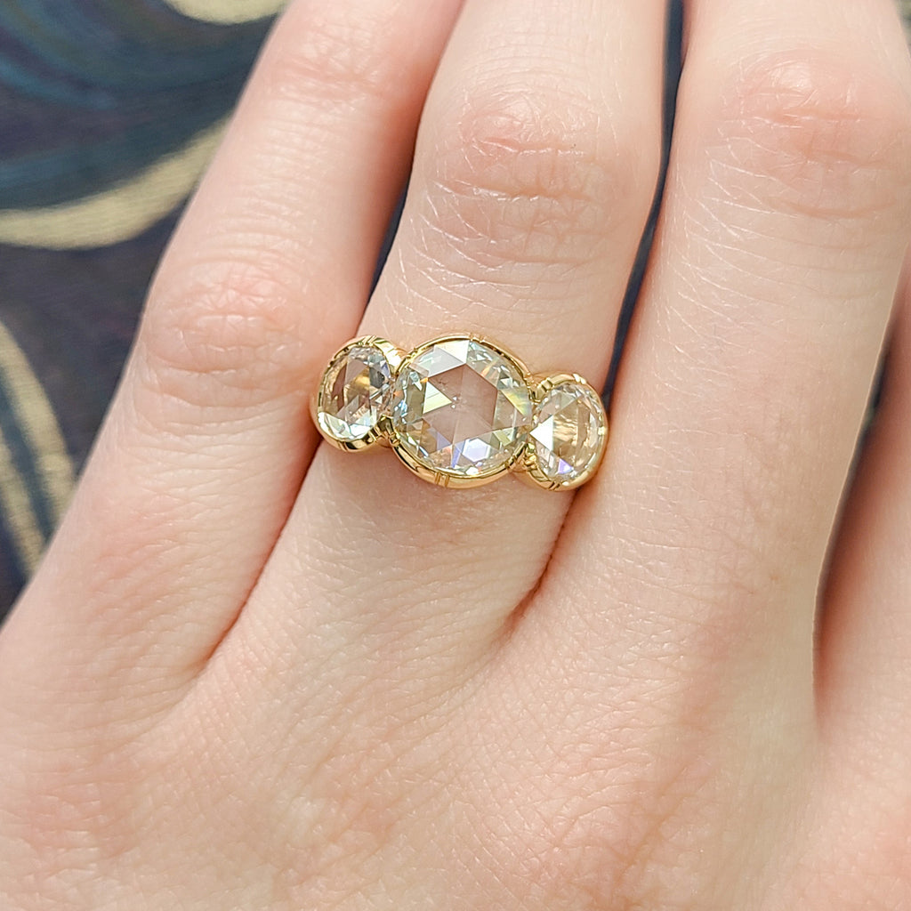 Single Stone's THREE STONE BROOKLYN ring  featuring 1.41ct L/SI1 GIA certified antique round rose cut diamond with 1.41ctw H-L/VS2-SI1 GIA certified rose cut accent diamonds bezel set in a handcrafted 18K yellow gold mounting.
