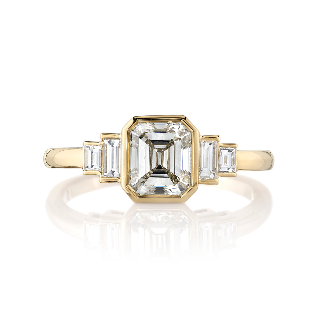 
Single Stone's Caroline ring  featuring 1.11ct M/SI2 GIA certified emerald cut diamond with 0.22ctw baguette cut accent diamonds bezel set in a handcrafted 18K yellow gold mounting.
