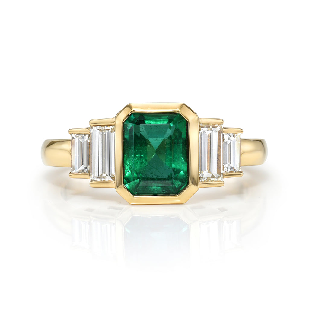 Single Stone's CAROLINE ring  featuring 1.46ct GIA certified Zambian emerald cut green emerald with 0.66ctw baguette cut accent diamonds bezel set in a handcrafted 18K yellow gold mounting.
