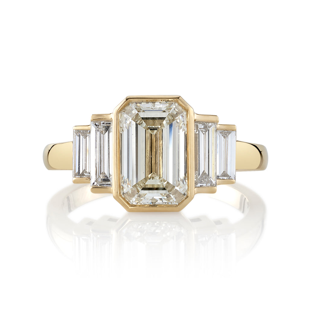
Single Stone's Caroline ring  featuring 2.01ct N/SI1 GIA certified emerald cut diamond with 0.76ctw baguette cut accent diamonds bezel set in a handcrafted 18K yellow gold mounting.
