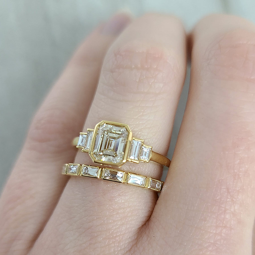 Single Stone's CAROLINE ring  featuring 1.11ct M/SI2 GIA certified emerald cut diamond with 0.22ctw baguette cut accent diamonds bezel set in a handcrafted 18K yellow gold mounting.
