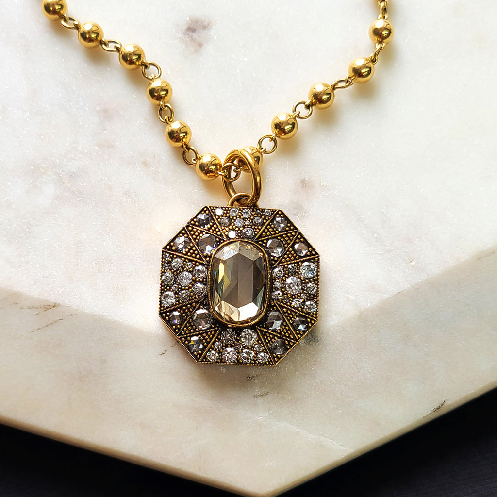 Single Stone's IVY pendant  featuring 5.93ct GIA certified Fancy Brown-Yellow/I2 oval rose cut diamond with 3.23ctw varying old, rose and round brilliant cut diamonds prong set in a handcrafted, oxidized 18K yellow gold pendant.
