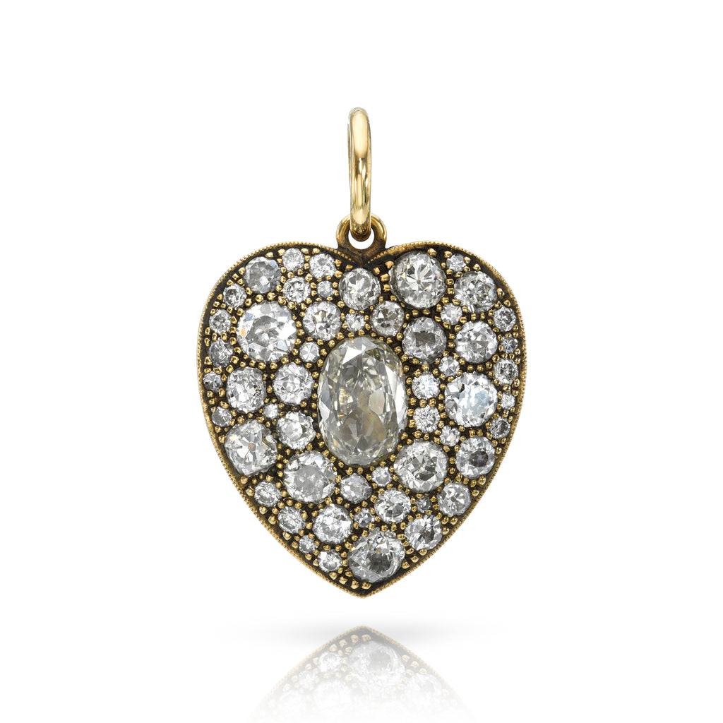 
Single Stone's Large cobblestone heart pendant  featuring 1.21ct N/VS1 GIA certified oval cut diamond surrounded by 3.75ctw varying old cut and round brilliant cut diamonds set in an oxidized, handcrafted 18K yellow gold heart-shaped pendant.
Price does not include chain.
