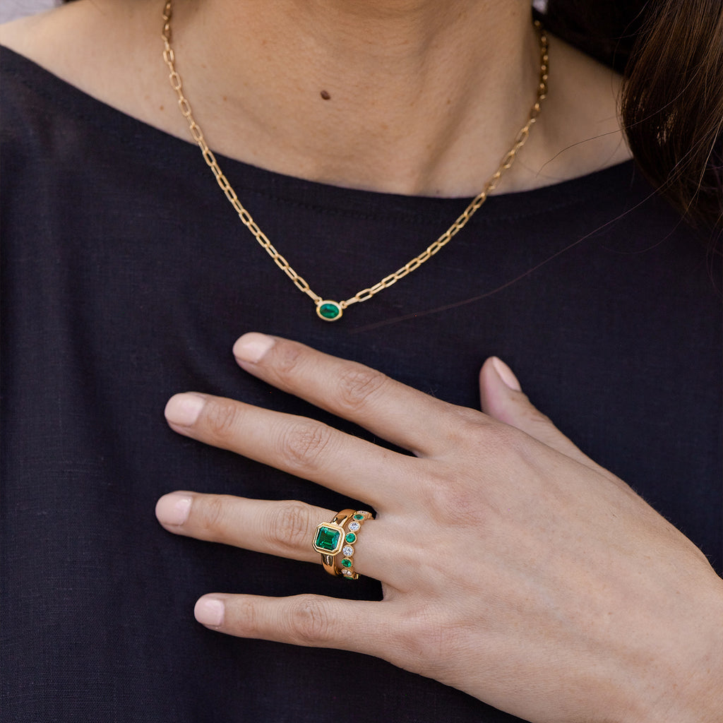 Single Stone's LEAH NECKLACE  featuring 0.89ct oval cut green emerald bezel set on a handcrafted 18K yellow gold pendant necklace. Necklace measures 17&quot;
