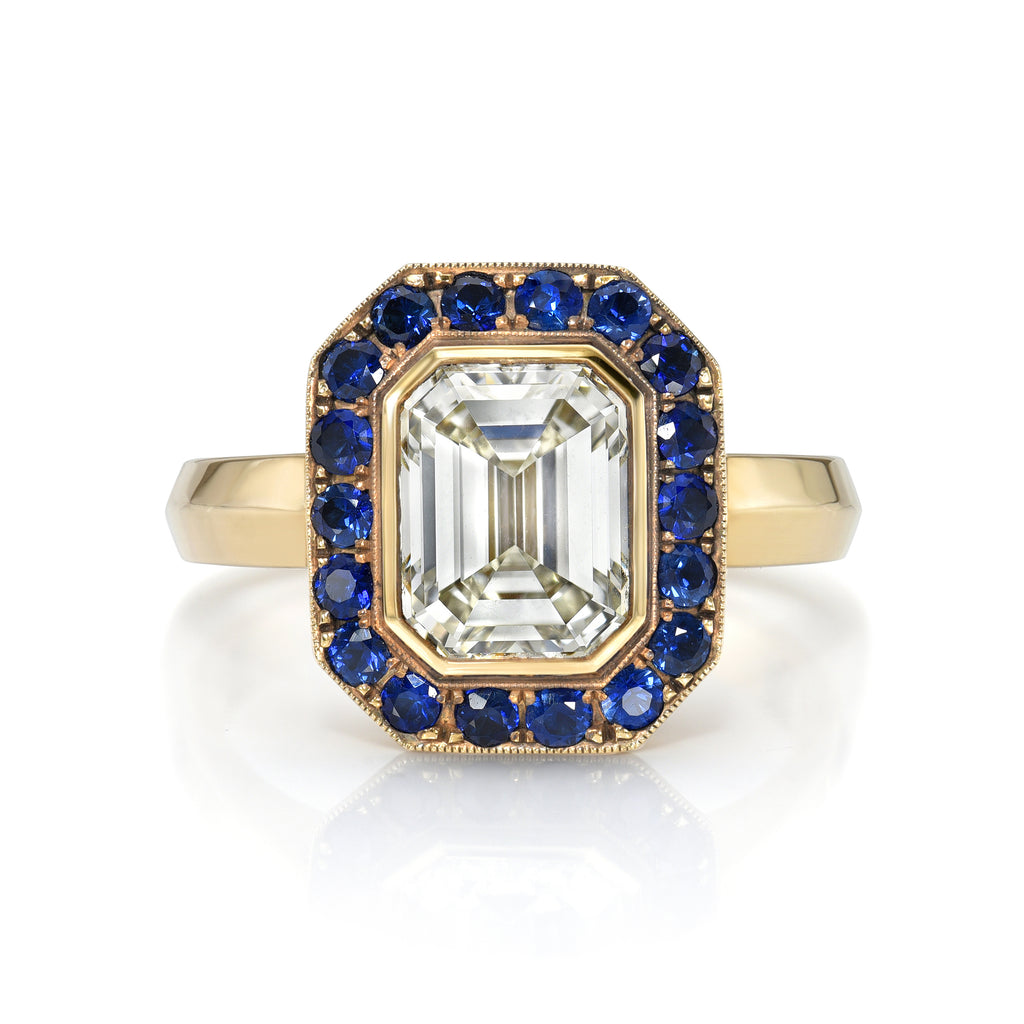
Single Stone's Maria pavé ring  featuring 2.00ct M/VS1 GIA certified bezel set emerald cut diamond with 0.55ctw round cut blue sapphire accent gemstones pavé set in a handcrafted, lightly oxidized 18K yellow gold mounting.
