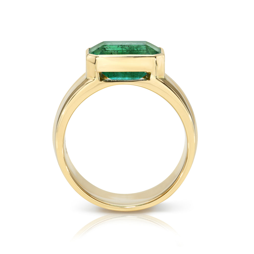 Single Stone's MISHA ring  featuring 3.15ct GIA certified emerald cut green emerald bezel set in a handcrafted 18K yellow gold wide cigar band
