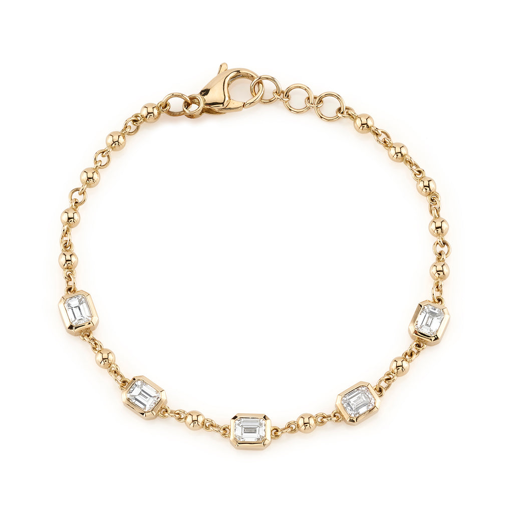 Single Stone's FIVE STONE SERALINA BRACELET  featuring Approximately 2.50ctw J-K/VS bezel set emerald cut diamonds on a handcrafted 18K yellow gold rosary bracelet. Prices may vary according to diamond weight.
