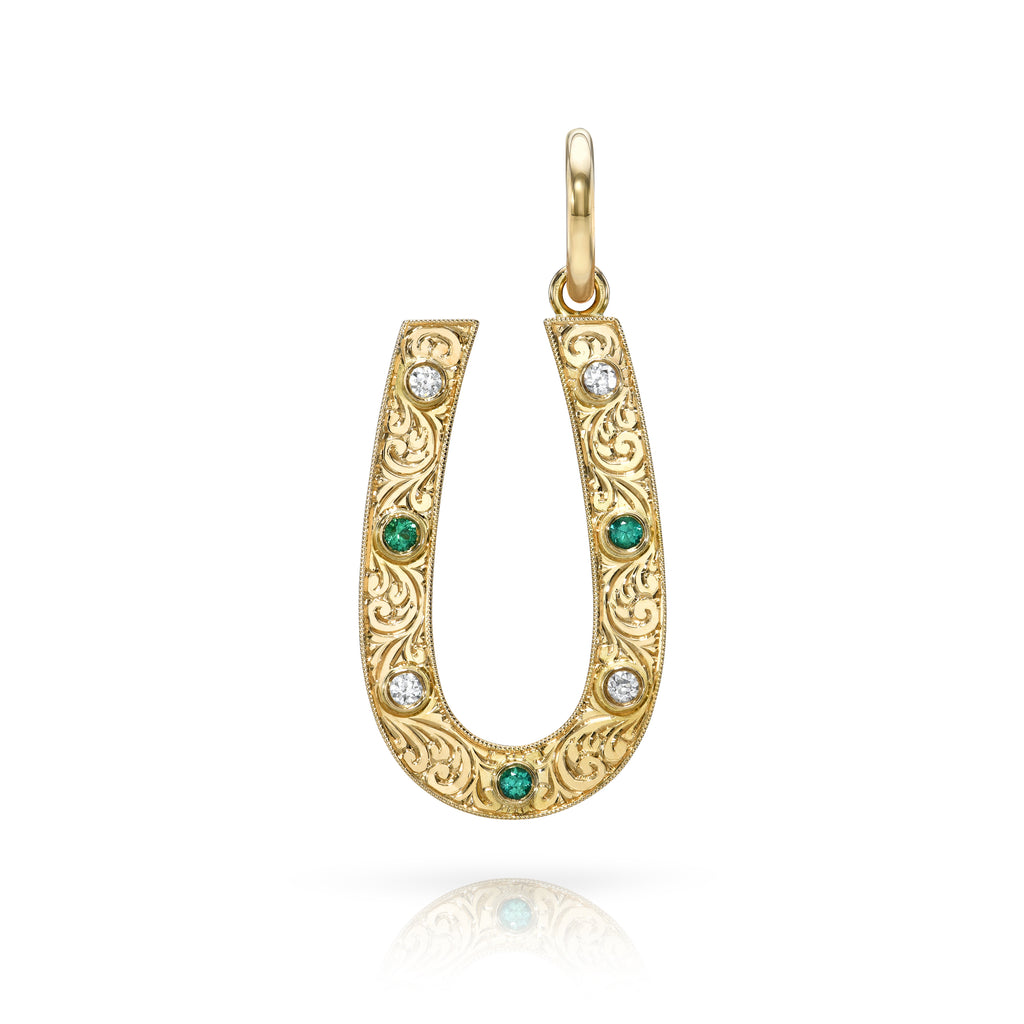 
Single Stone's Small marilyn with diamonds and gemstones pendant  featuring Approximately 0.14 - 0.16ctw old European cut diamonds and 0.10ctw old European cut green emeralds bezel set in a handcrafted, hand engraved, 18K yellow gold horseshoe shaped pendant.
Price does not include chain.

