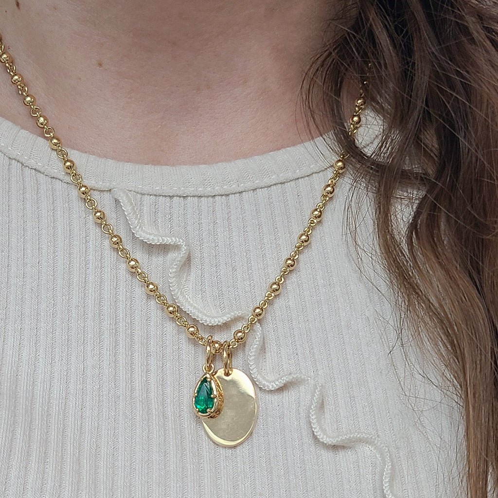 Single Stone's SAMARA PENDANT pendant  featuring 0.76ct pear shape green emerald prong set in a handcrafted, hand engraved 18K yellow gold drop pendant.
