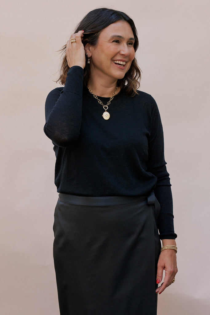 Single Stone Designer Corina Madilian wearing Single Stone jewelry, smiling and looking off camera