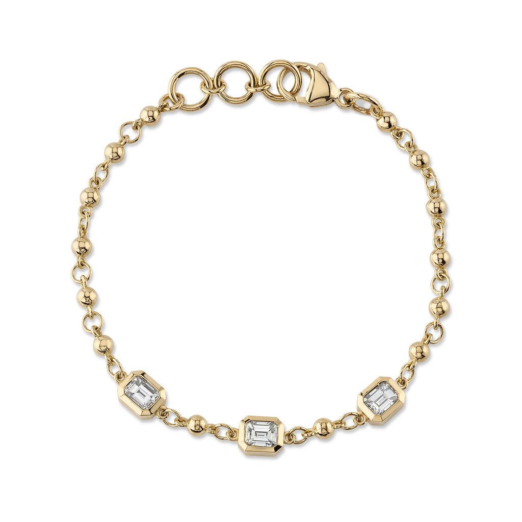Single Stone's THREE STONE SERALINA BRACELET  featuring Approximately 1.50ctw J-K/VS emerald cut diamonds bezel set on our handcrafted 18K yellow gold Rosary bracelet. Prices may vary according to diamond weight. Bracelet measures 7.5&quot;.
