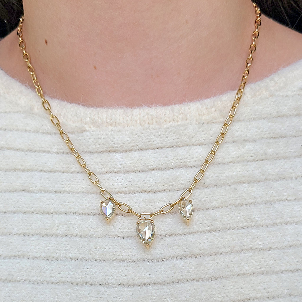 Single Stone's THREE STONE CAILYN NECKLACE  featuring 4.12ctw O-P/VS-I1 pear shaped rose cut diamonds prong set on a handcrafted 18K yellow gold pendant necklace. Necklace measures 17&quot;. 
