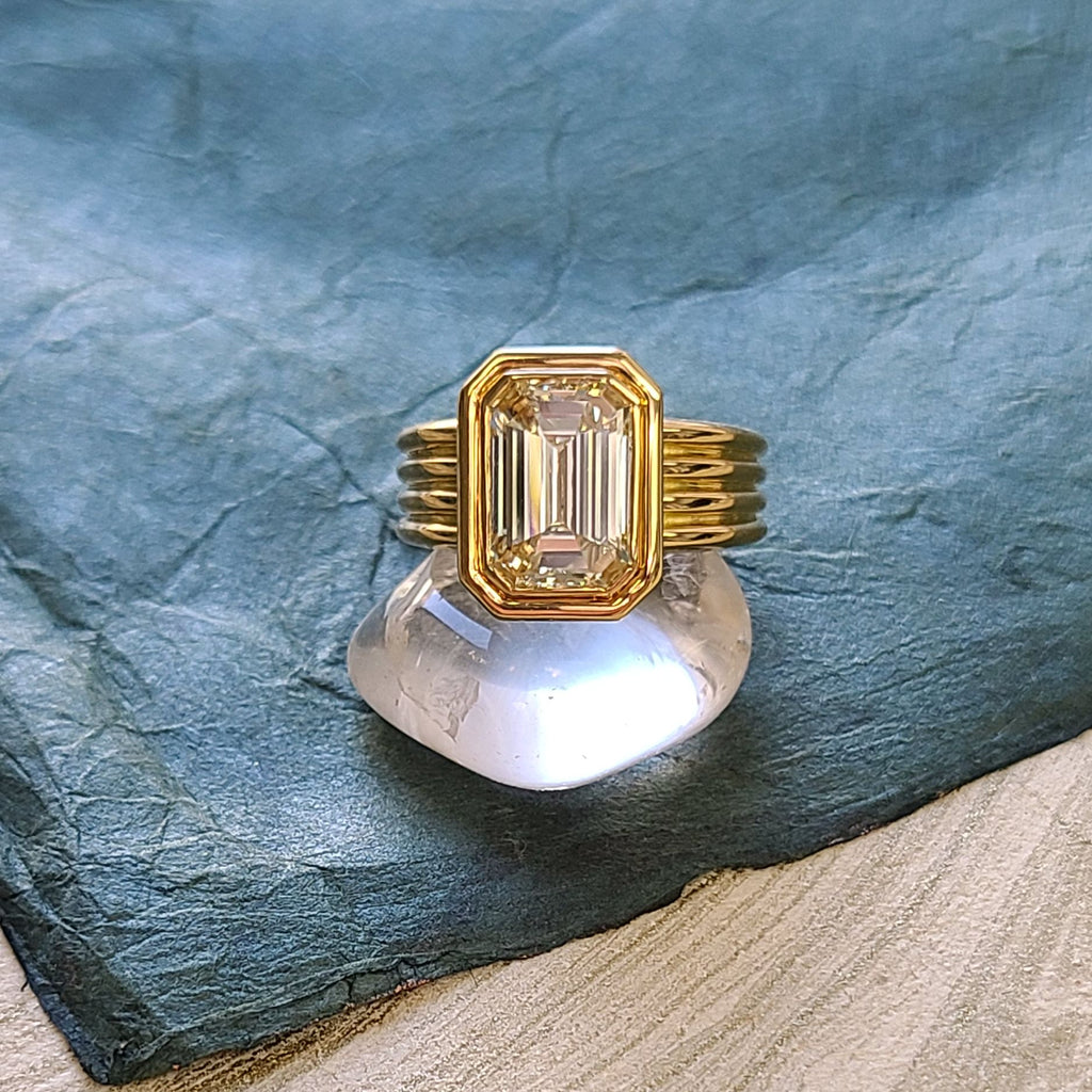 'Eleni' ring featuring a 4.02ct S-T/SI1 GIA-certified emerald cut diamond bezel set in a handcrafted 18K yellow gold mounting