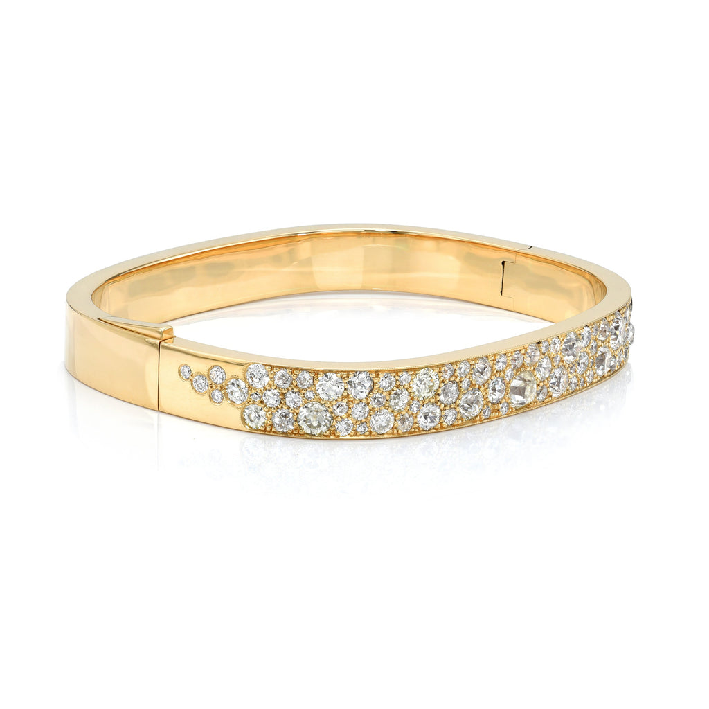 Single Stone's ALEX BANGLE, COBBLESTONE  featuring 6.37ctw various old cut and round brilliant cut diamonds set in a handcrafted 18K yellow gold bangle bracelet. Cobblestone pattern may vary from piece to piece.
