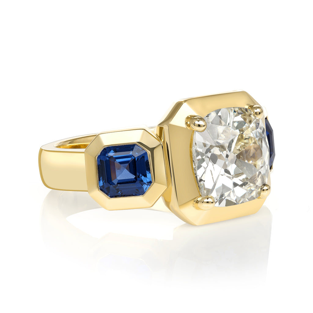 Single Stone's GLORIA ring  featuring 2.86ct O-P/I2 GIA certified antique cushion cut diamond with 1.50ctw Asscher cut blue sapphires set in a handcrafted 18K yellow gold mounting.  
