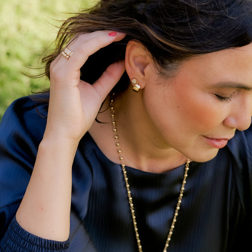 Single Stone's JENNI HUGGIES earrings  featuring Handcrafted high polished 18K yellow gold huggie hoop earrings.
