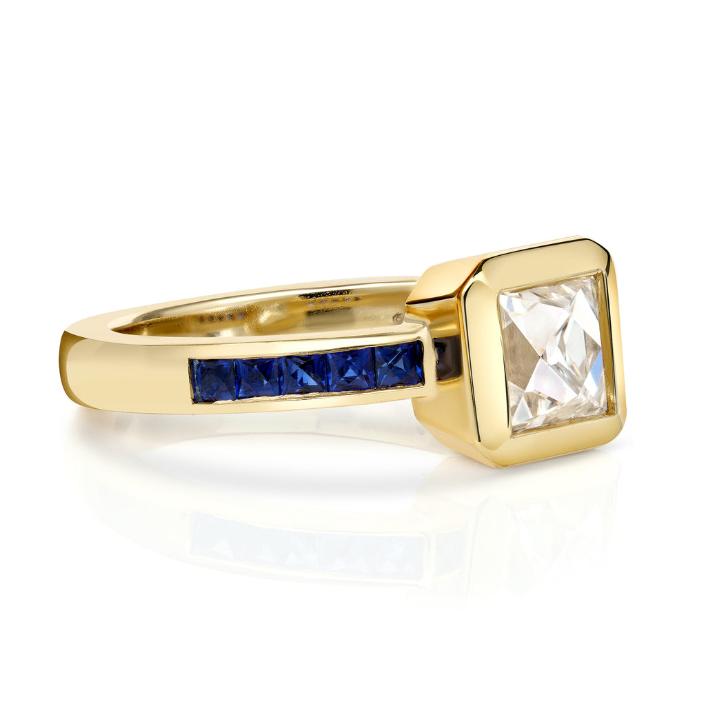 Single Stone's KARINA ring  featuring 1.15ct K/VS1 GIA certified French cut diamond with 0.39ctw French cut blue sapphire accent stones bezel set in a handcrafted 18K yellow gold mounting.
