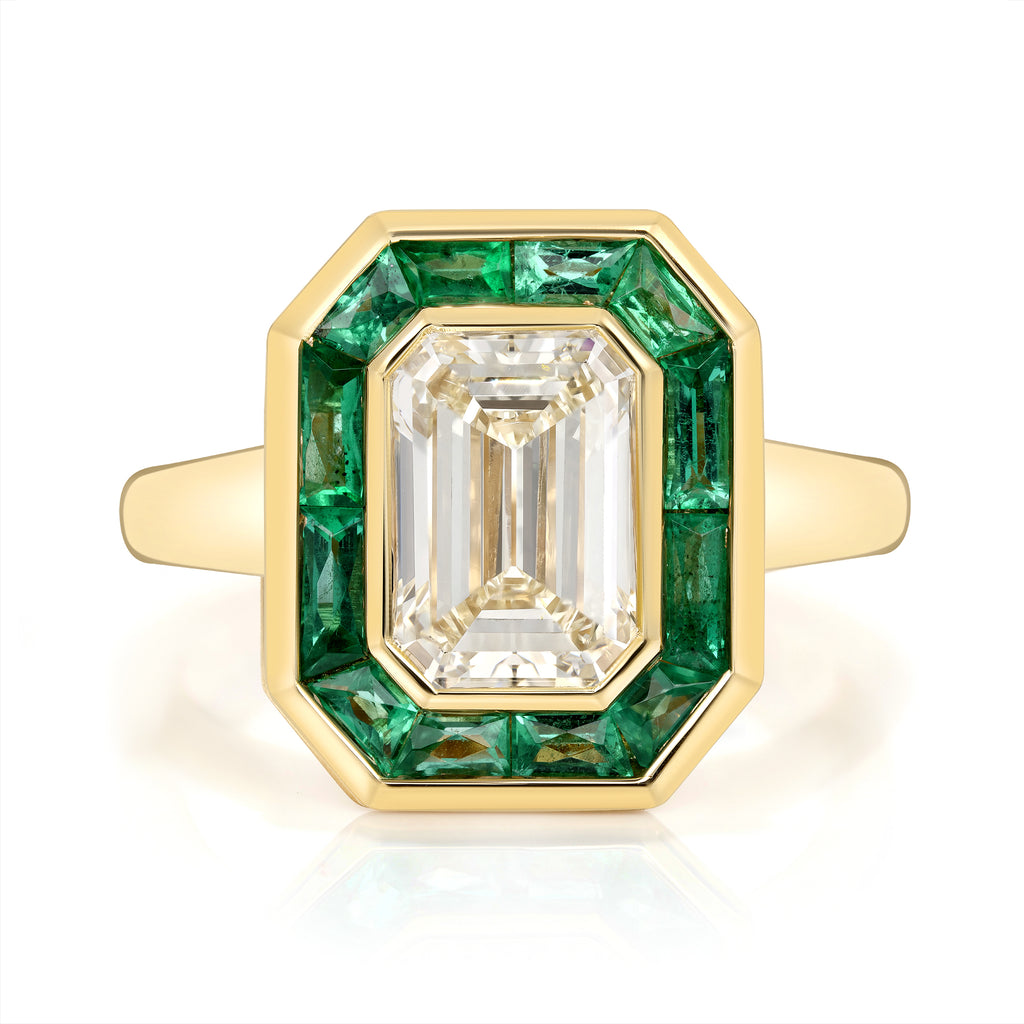 
Single Stone's Maria ring  featuring 2.11ct N/VS1 GIA certified emerald cut diamond with 0.92ctw French cut green emeralds bezel set in a handcrafted 18K yellow gold mounting.
