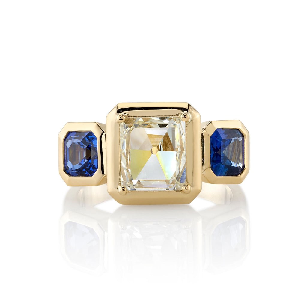 Single Stone's GLORIA ring  featuring 1.77ct K/VS1 GIA certified rectangular mixed cut diamond with 1.65ctw blue sapphire accent stones set in a handcrafted 18K yellow gold mounting.

