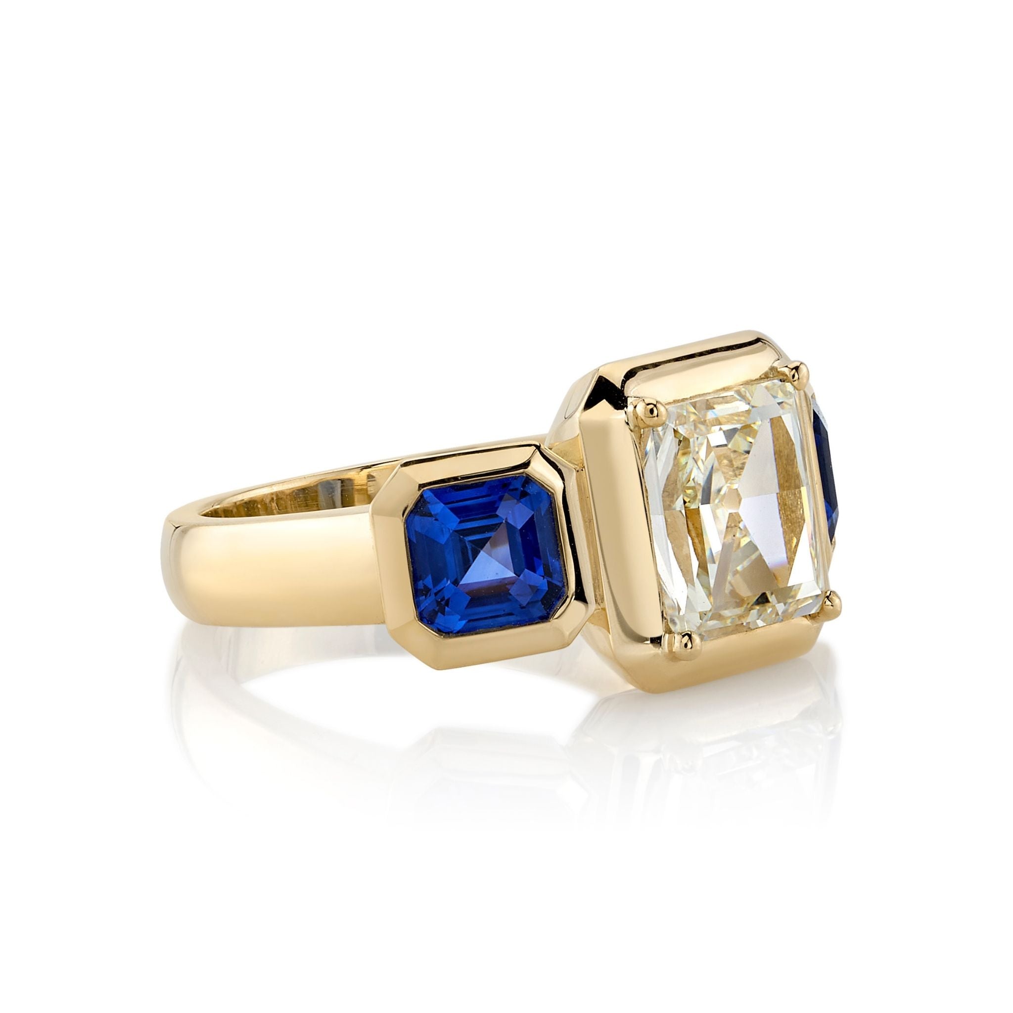 SINGLE STONE GLORIA RING featuring 1.77ct K/VS1 GIA certified rectangular mixed cut diamond with 1.65ctw blue sapphire accent stones set in a handcrafted 18K yellow gold mounting.
