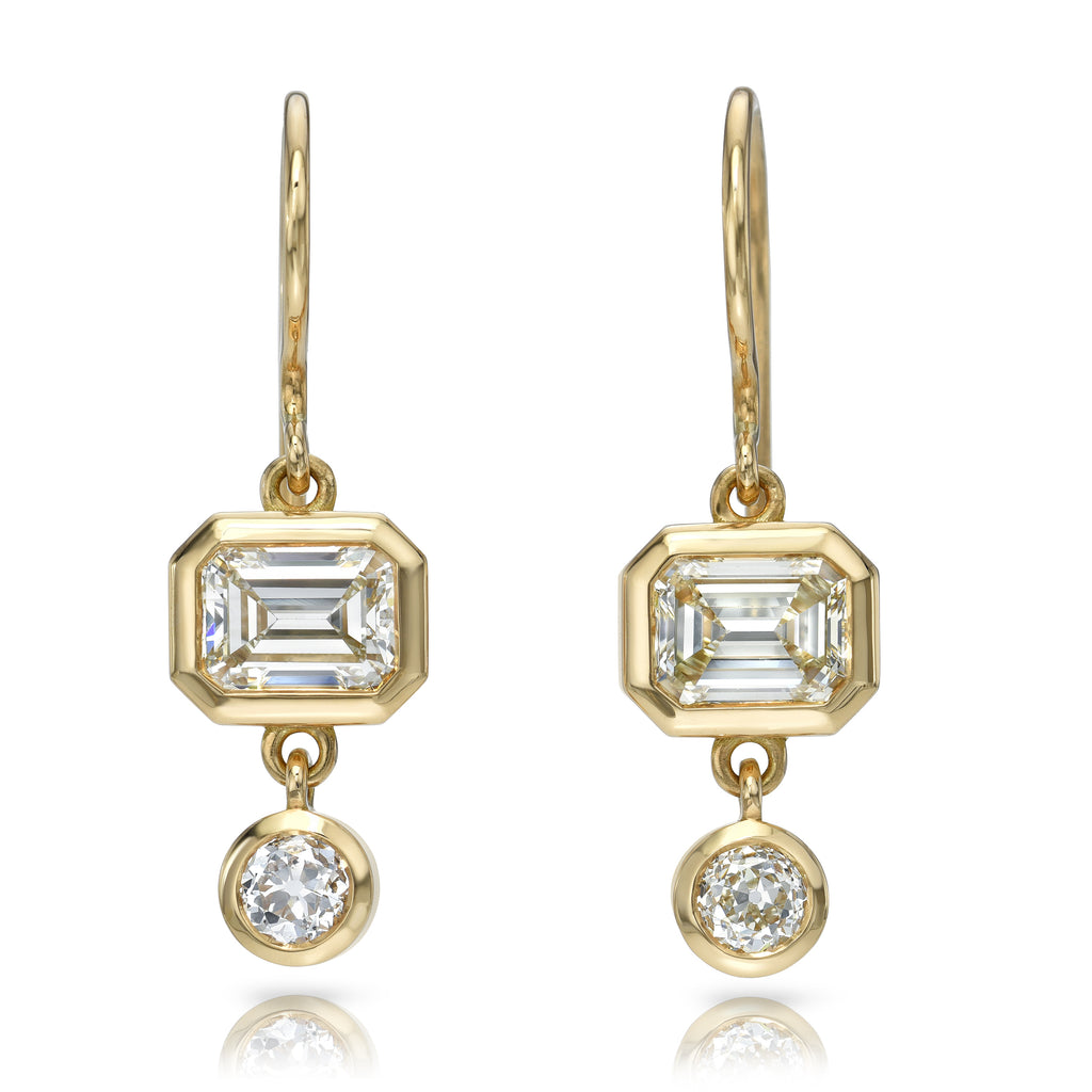 
Single Stone's Paloma double drops earrings  featuring 2.04ctw L/SI1 GIA certified emerald cut diamonds with 0.46ctw old mine cut accent diamonds bezel set in handcrafted 18K yellow gold drop earrings.
