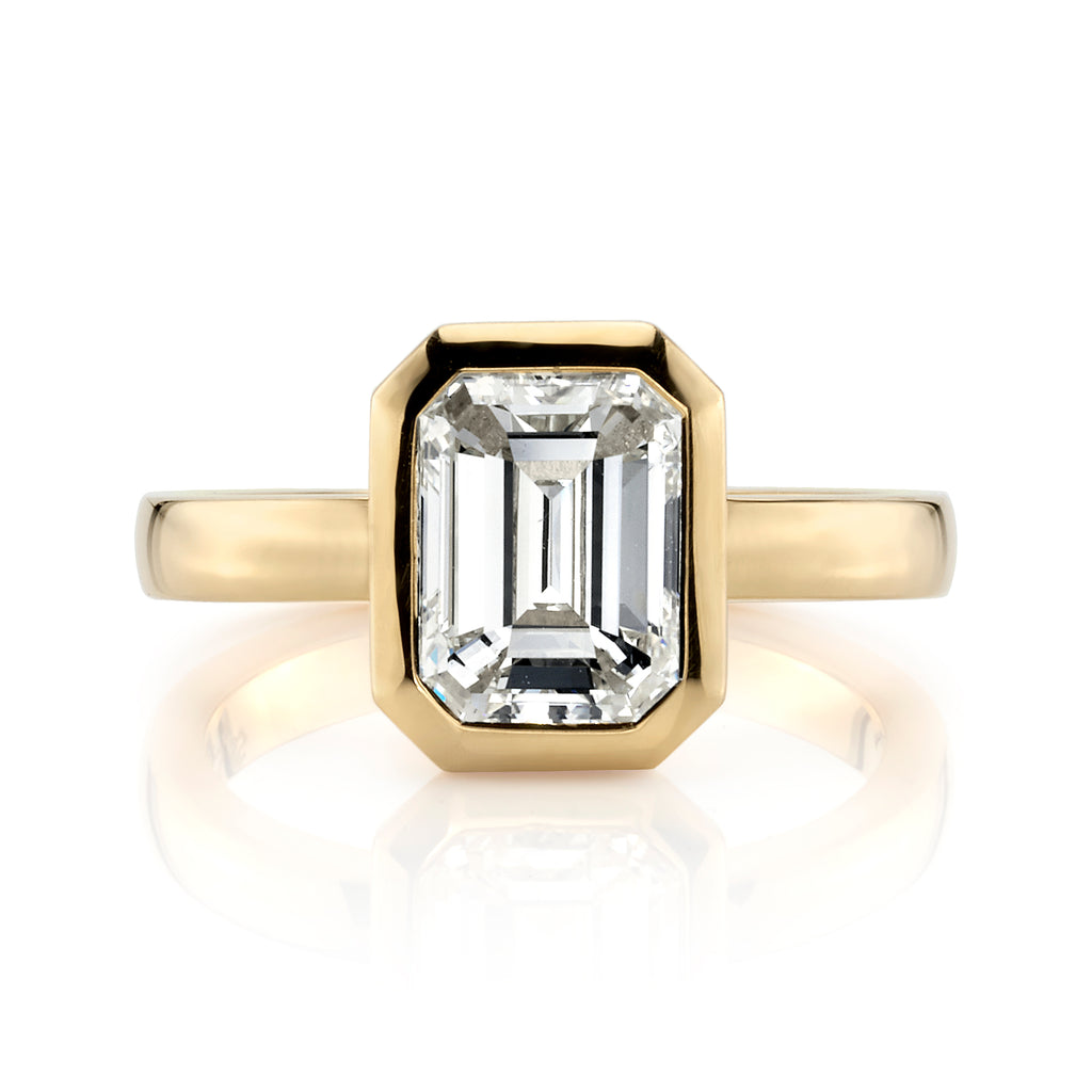 
Single Stone's Rae ring  featuring 2.03ct N/VS1 GIA certified emerald cut diamond bezel set in a handcrafted 18K yellow gold mounting.
