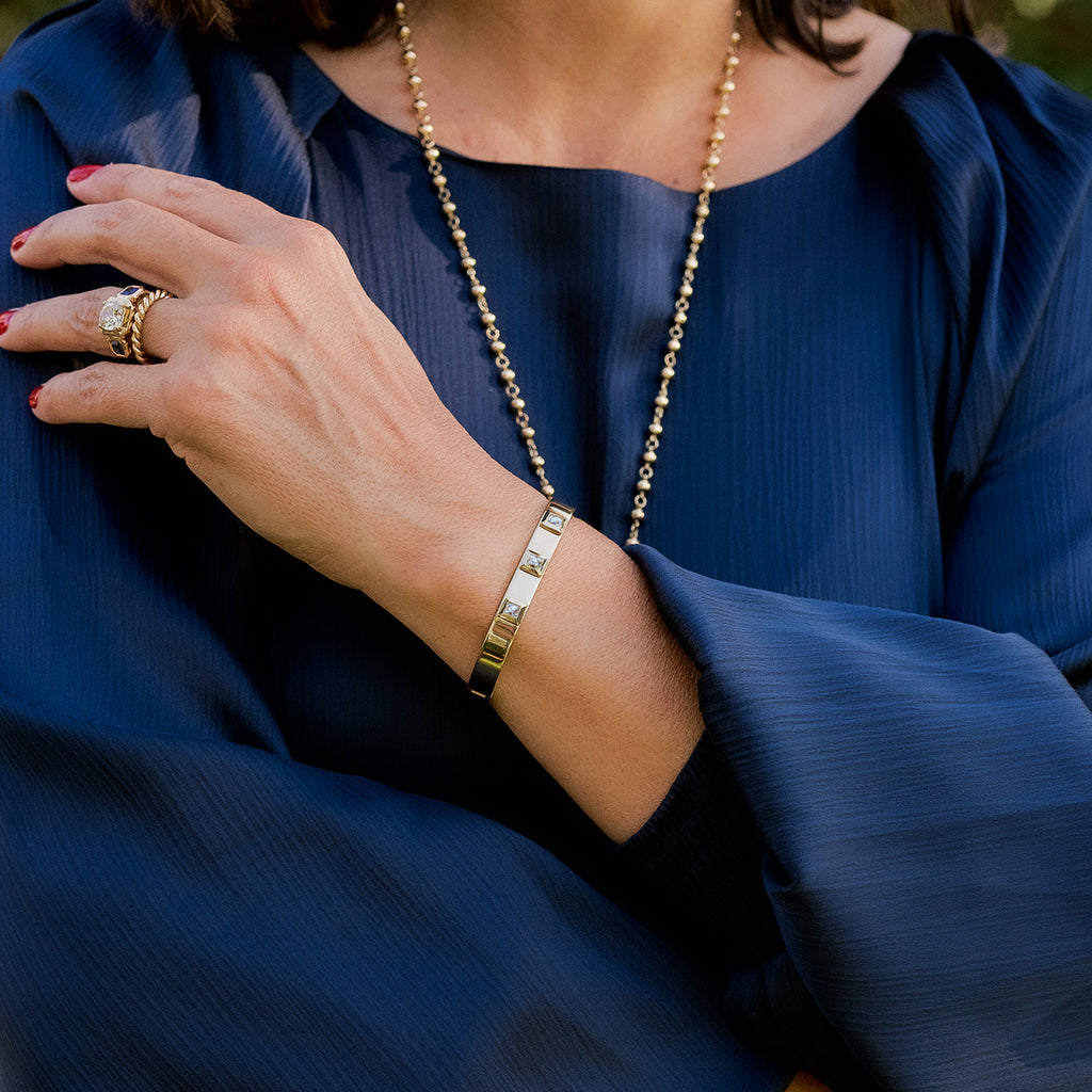 Single Stone's KARINA BANGLE  featuring 1.00ctw H-I/VS French cut diamonds bezel set in a handcrafted 18K yellow gold bangle bracelet.
